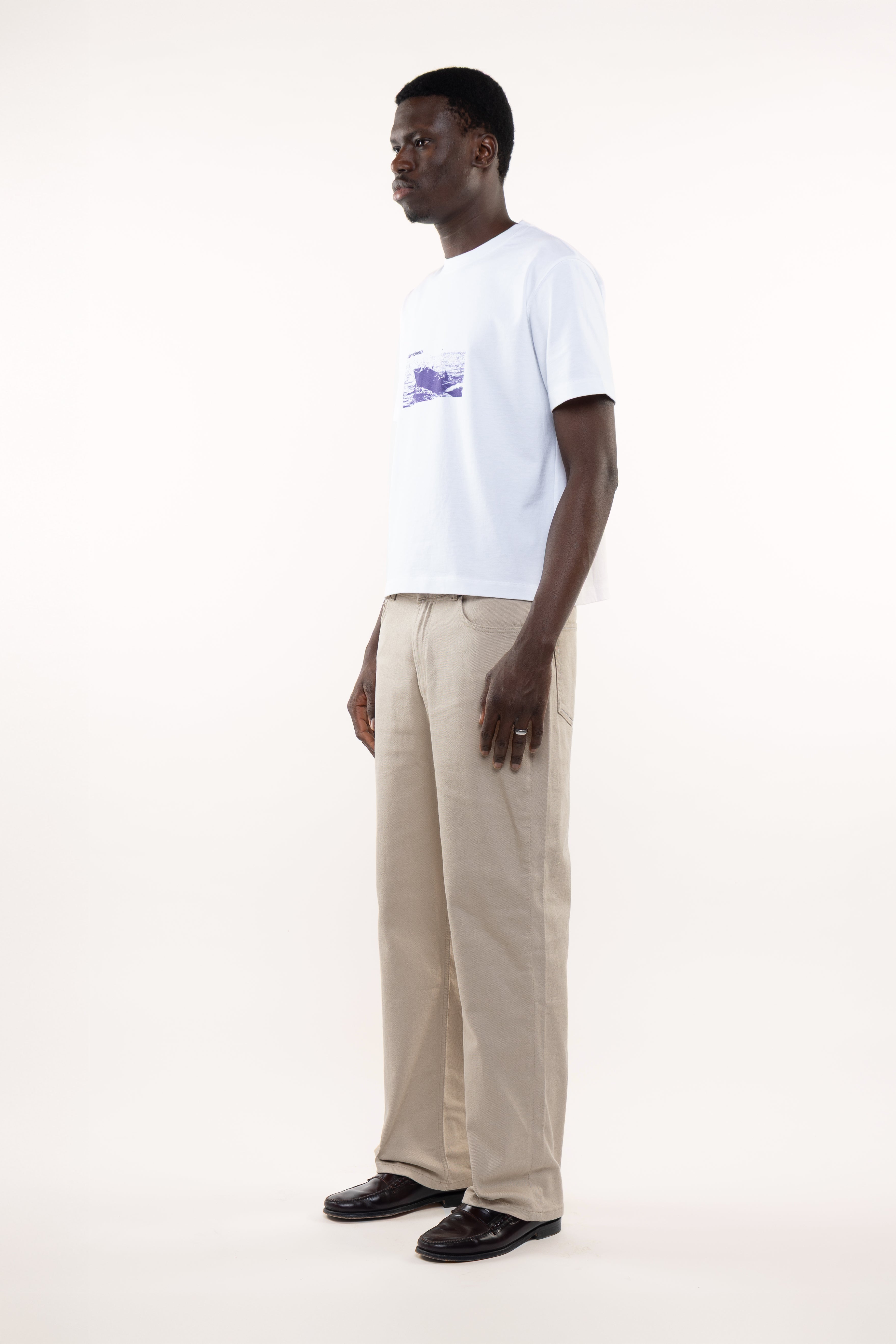 Side profile of men’s white T-shirt showing classic boat print partially visible on the front