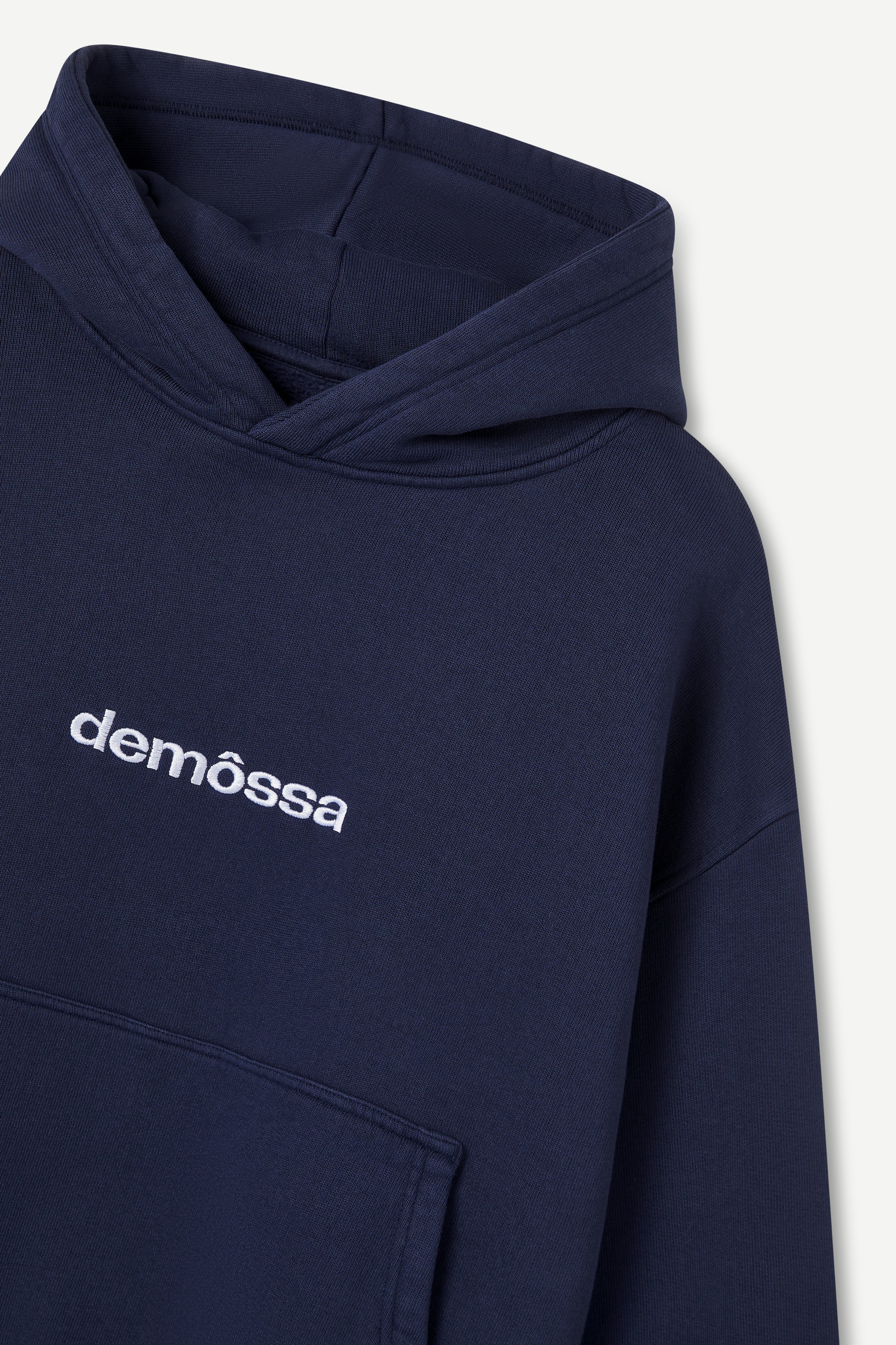 Navy blue hoodie with 'demossa' logo on a light gray background