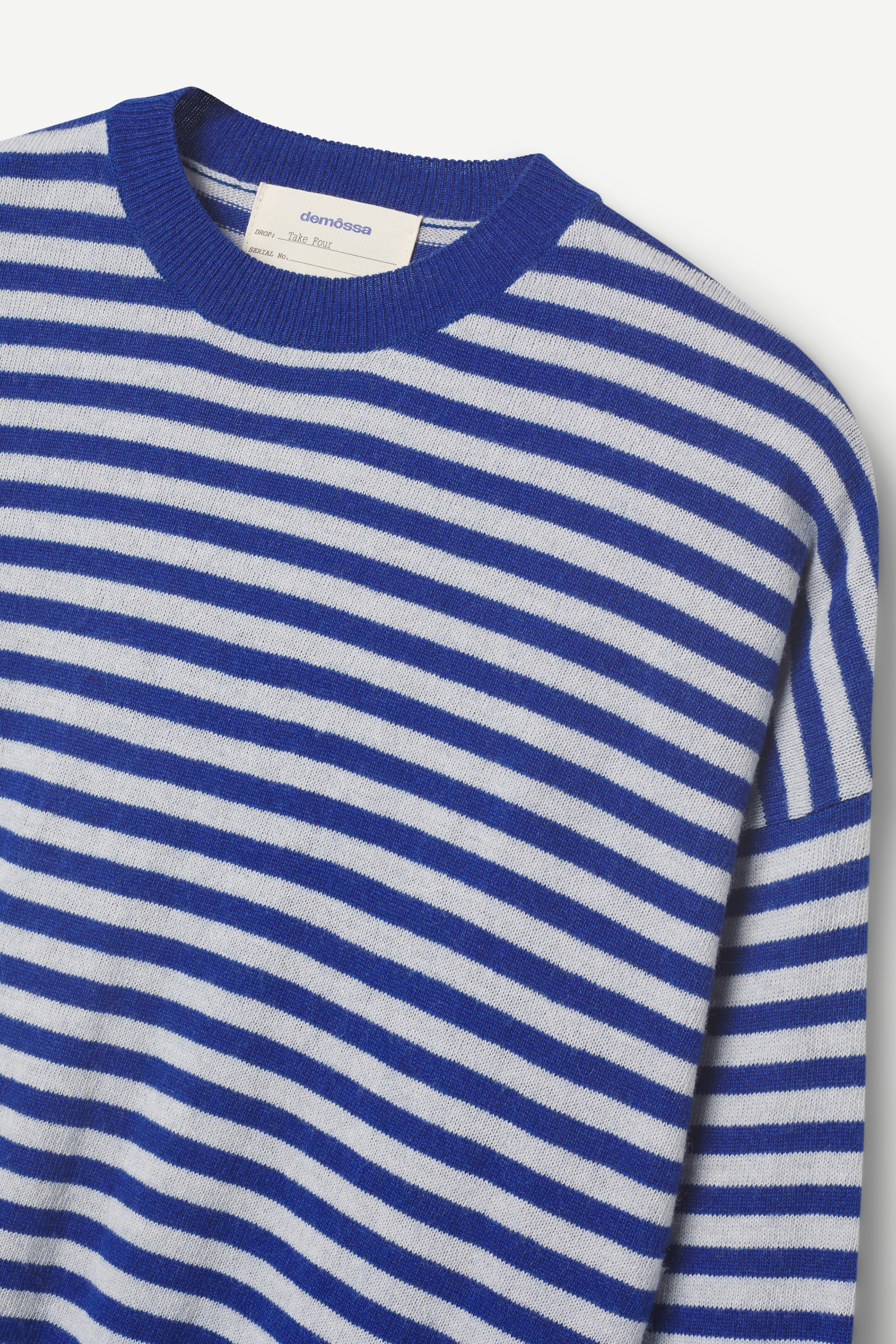 Blue and light gray striped sweater on a light gray background