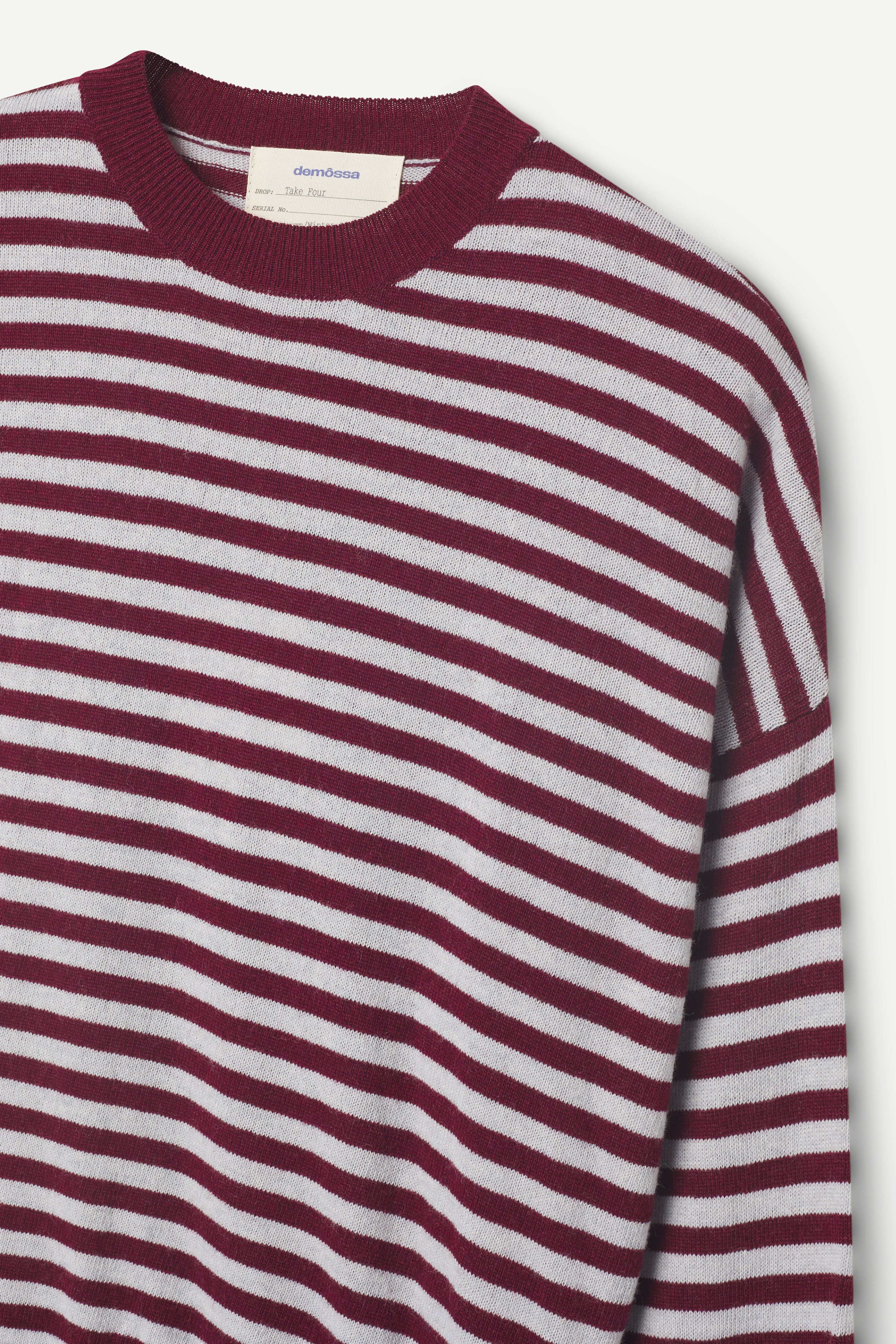 burgundy and light gray striped sweater on a light gray background