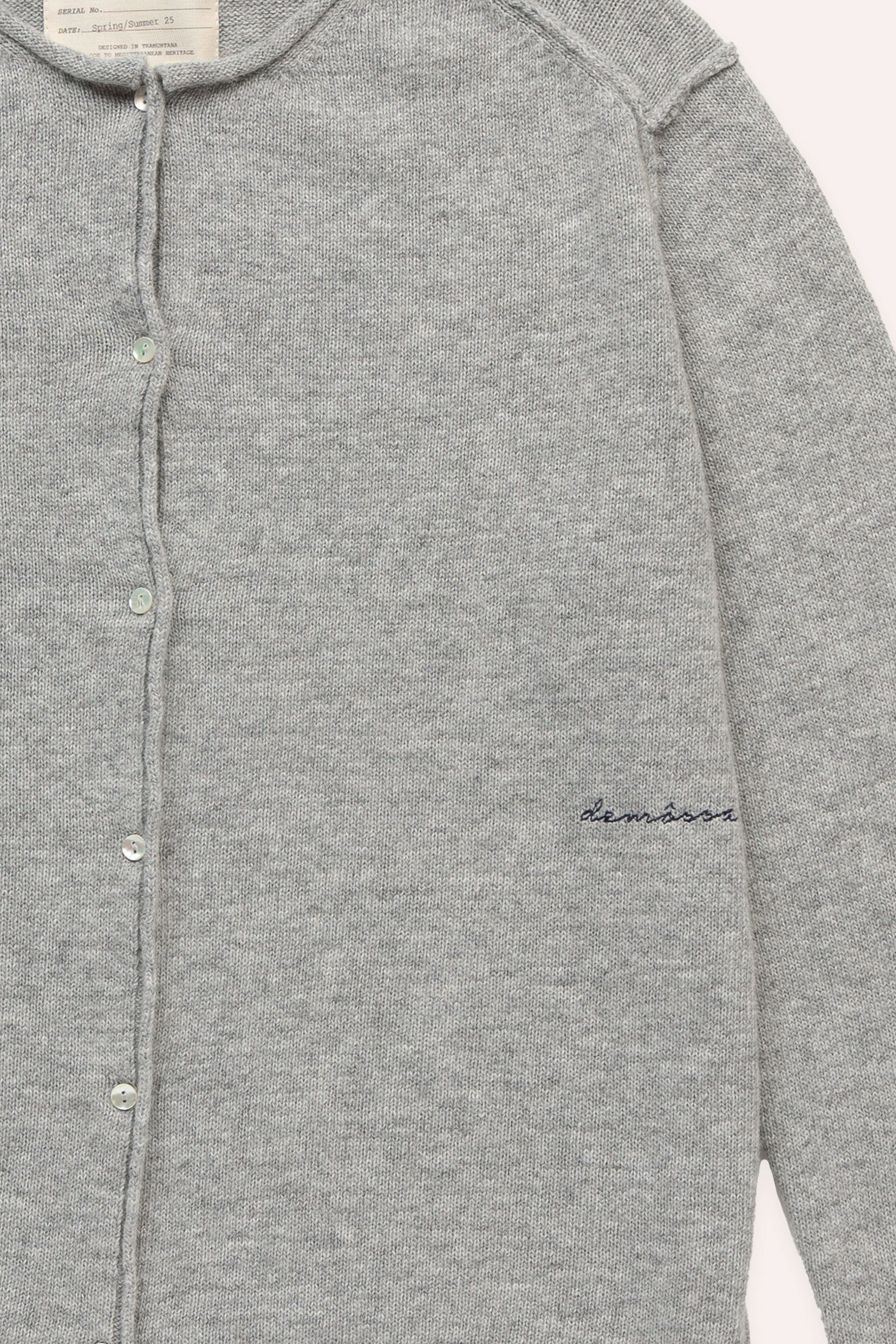 Close-up of tonal Demossa embroidery on right front panel of grey cardigan