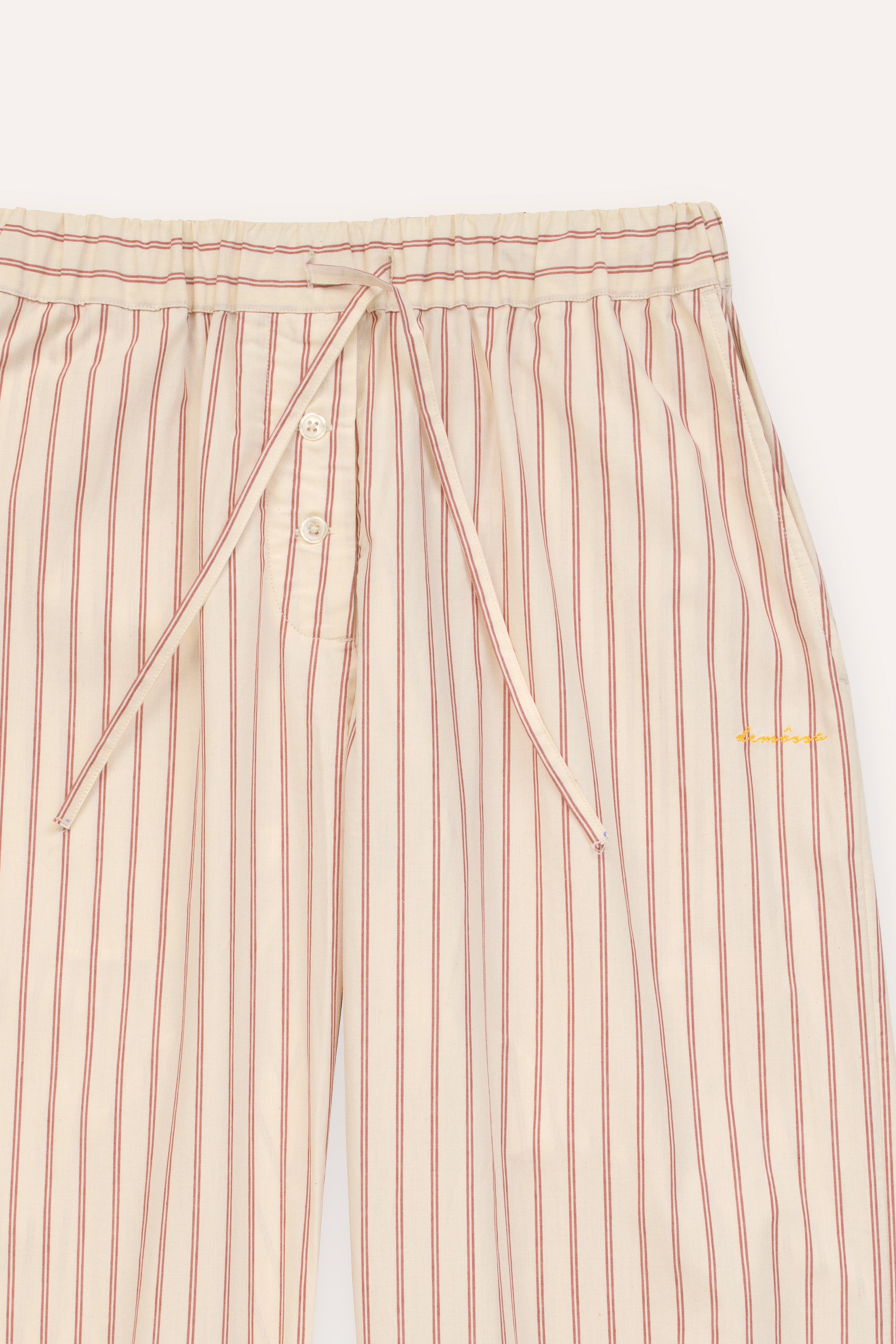 Striped pants with a button detail and "demossa" logo embroided on a white background