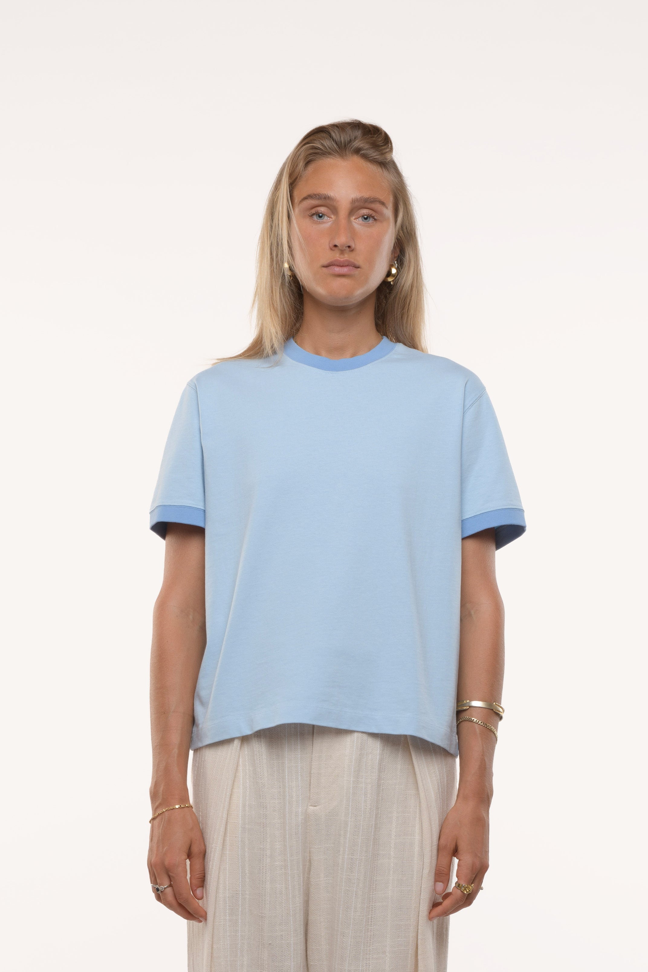 Woman wearing a light blue t-shirt against a white background