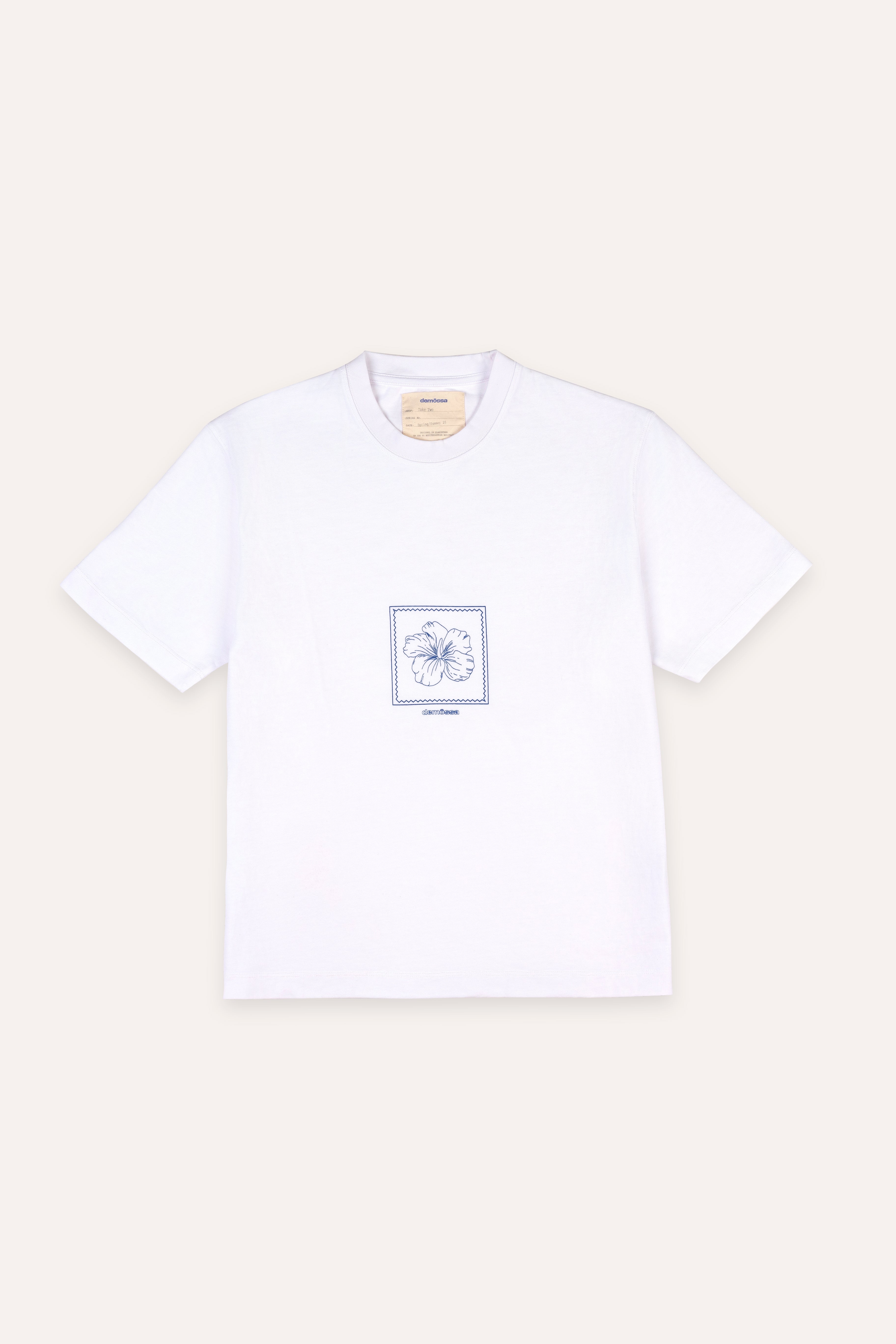 White t-shirt with a small graphic on a beige background