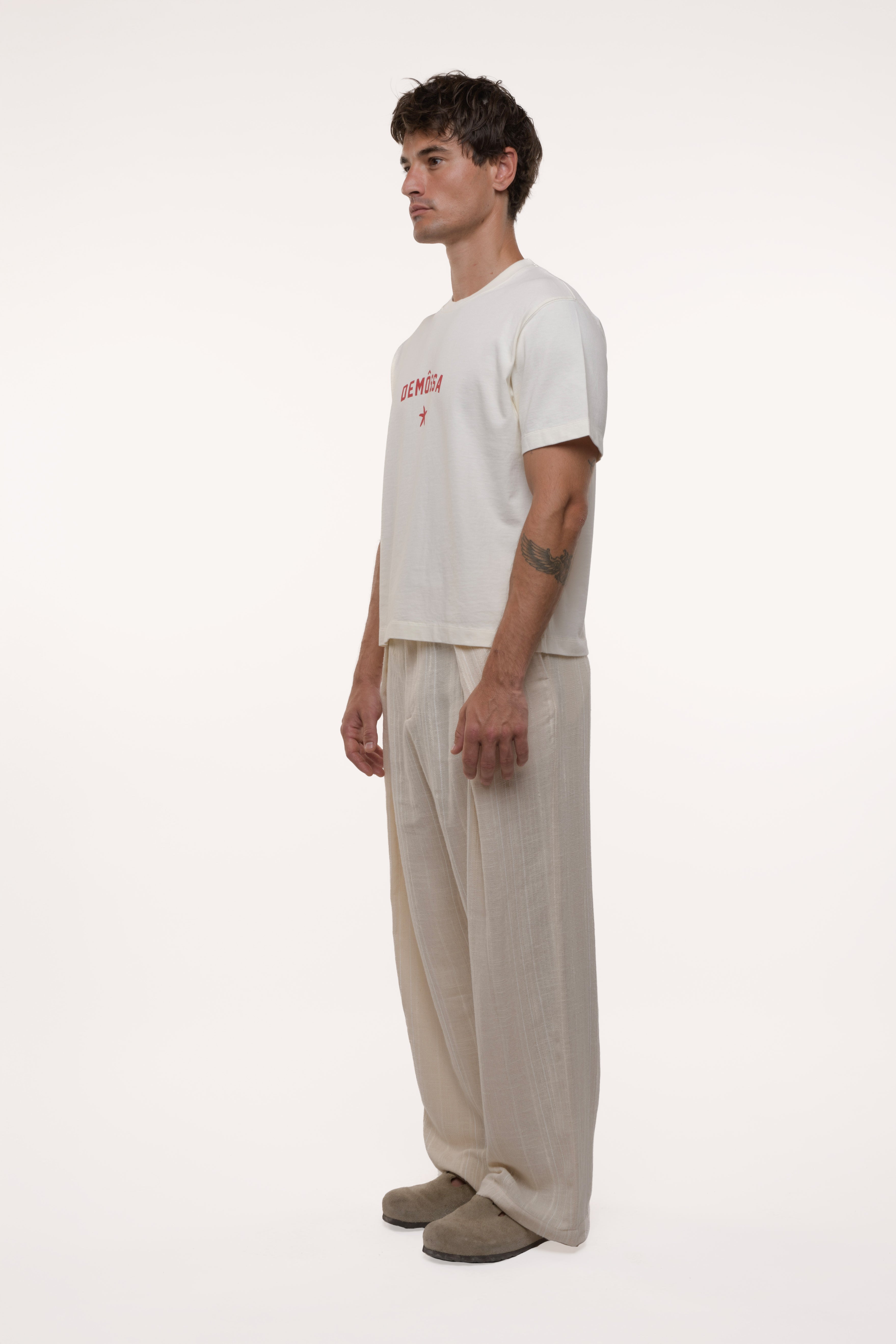 Man wearing a white t-shirt and beige pants on a white background
