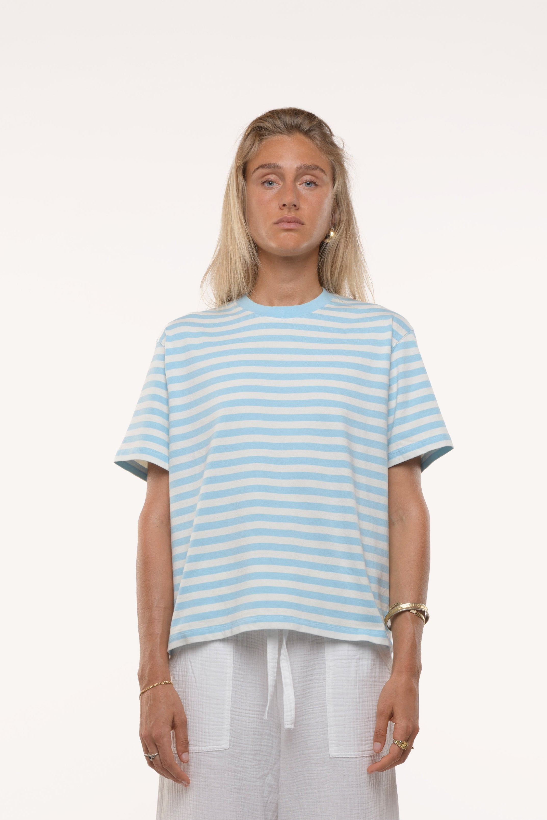 Woman wearing a light blue and white striped t-shirt on a white background