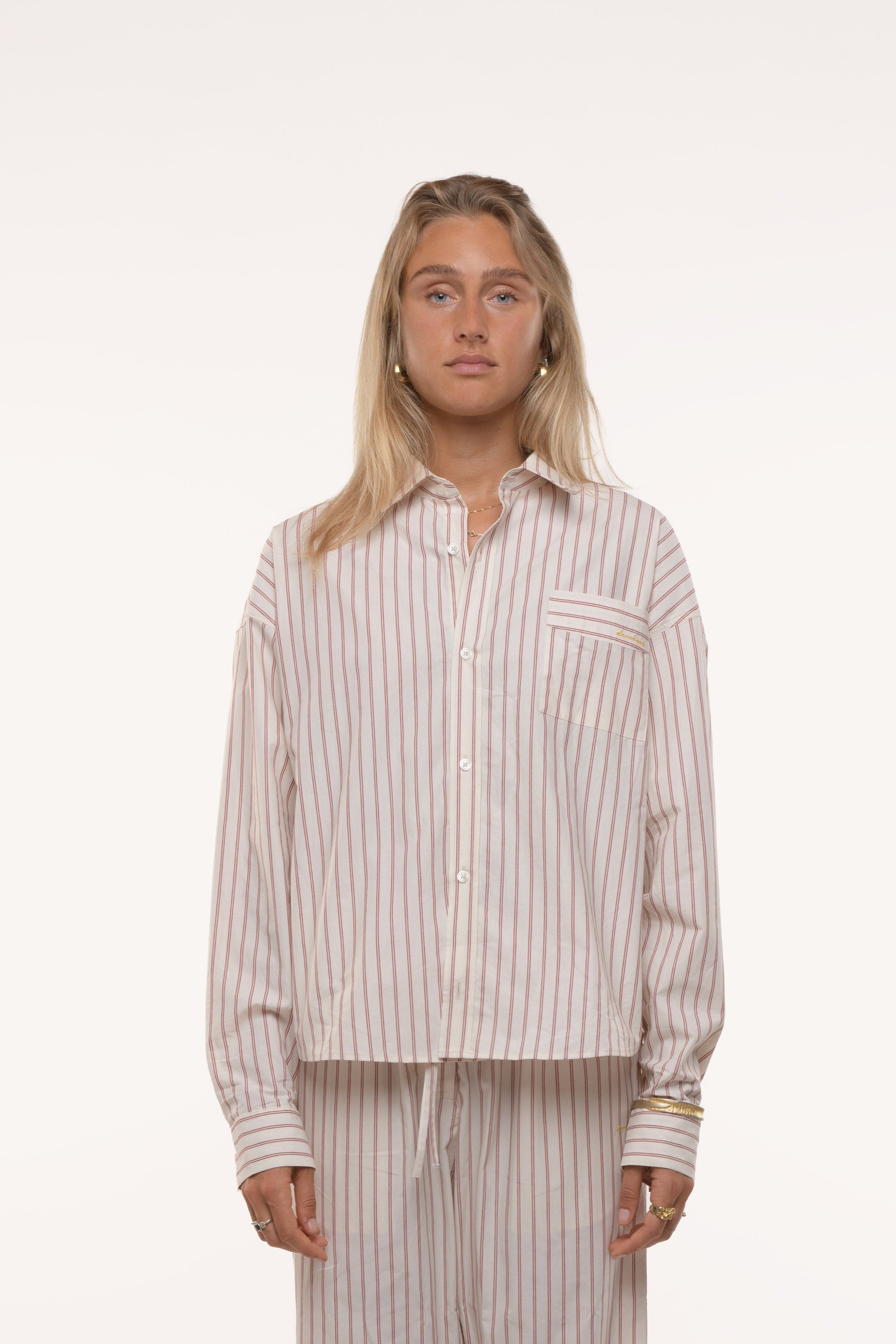 Woman wearing a striped shirt and pants on a white background