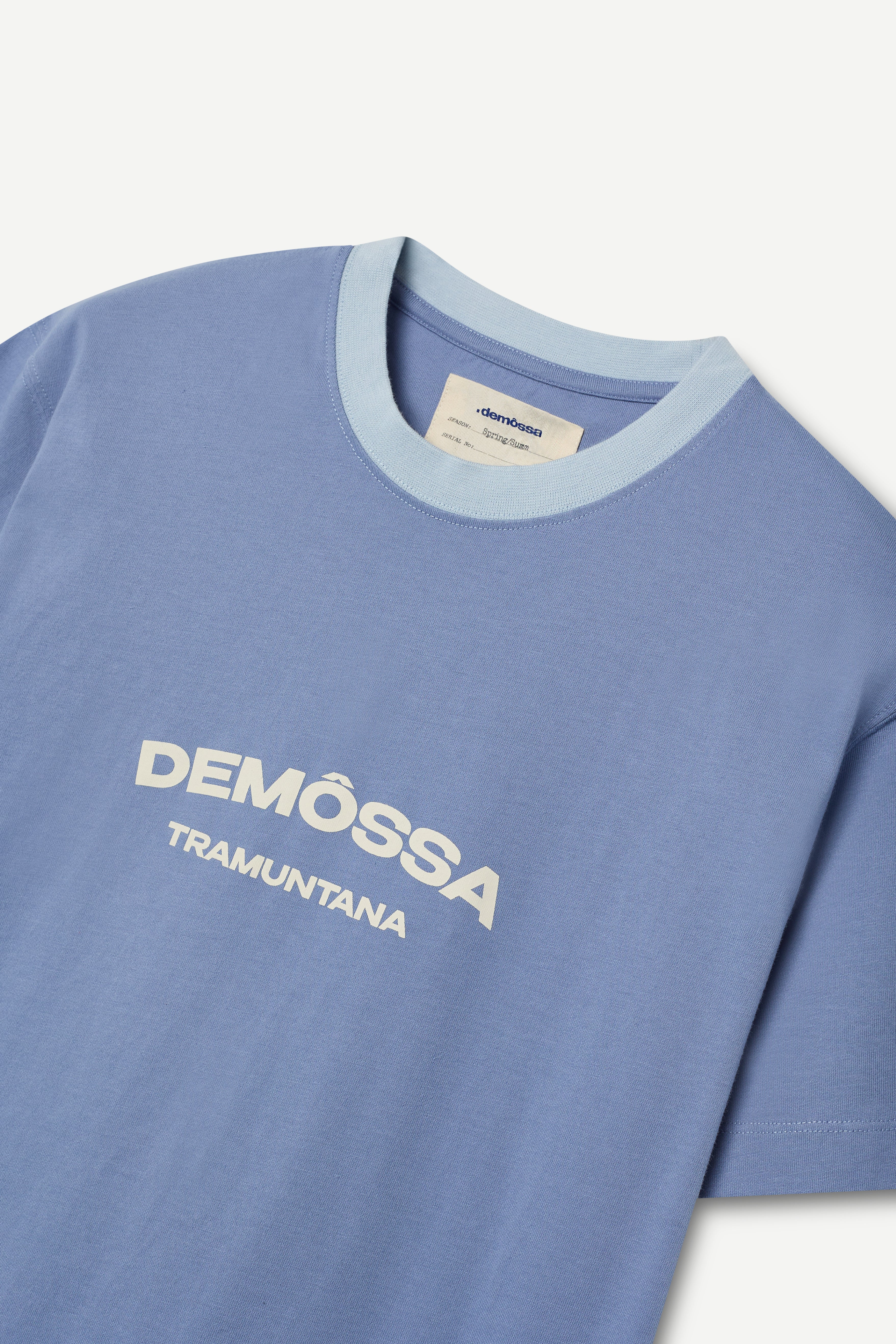 front view of a regular fit blue short-sleeved t-shirt with ivory demôssa print on the chest