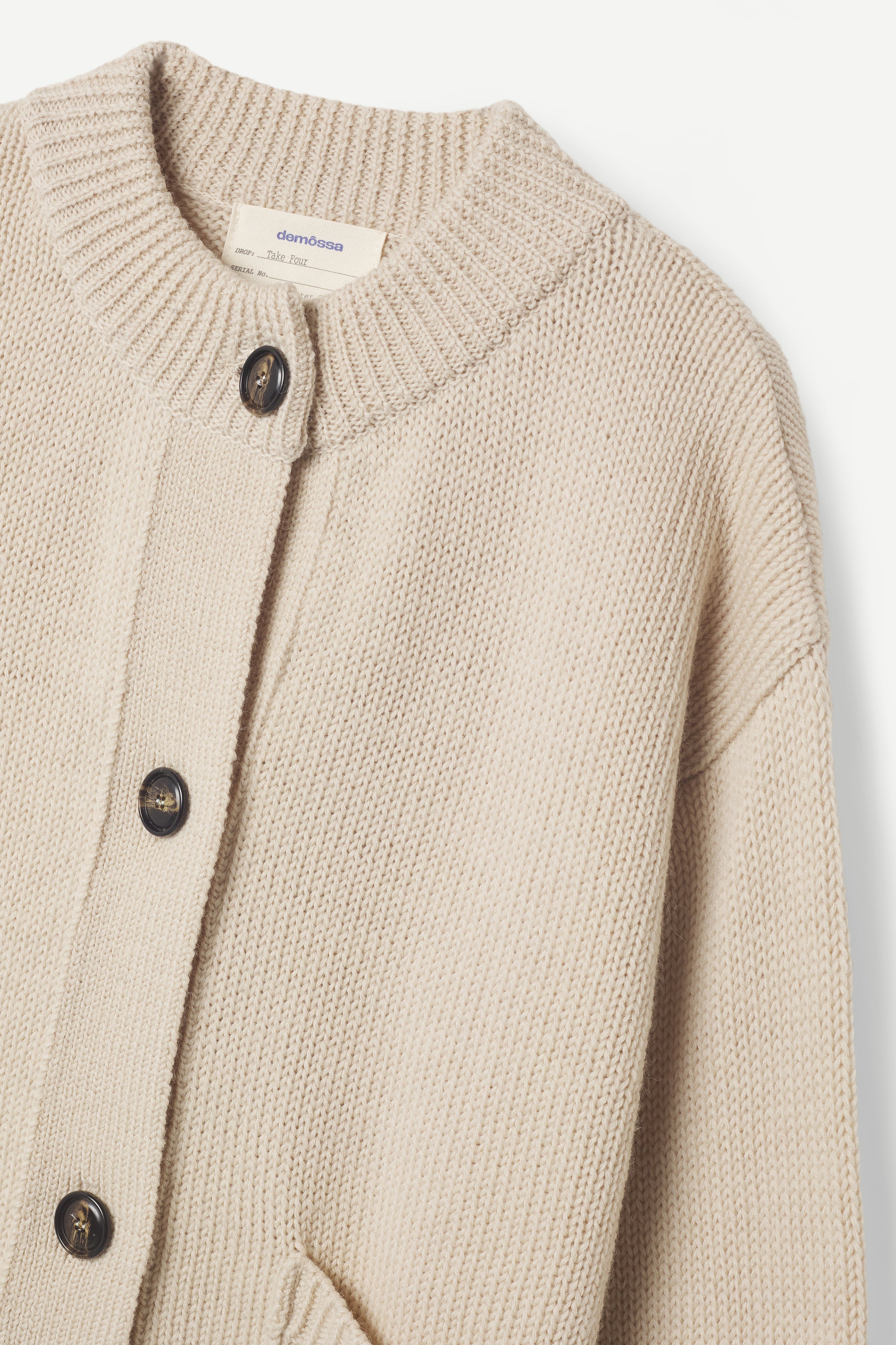 Beige knitted cardigan with button details on a white background