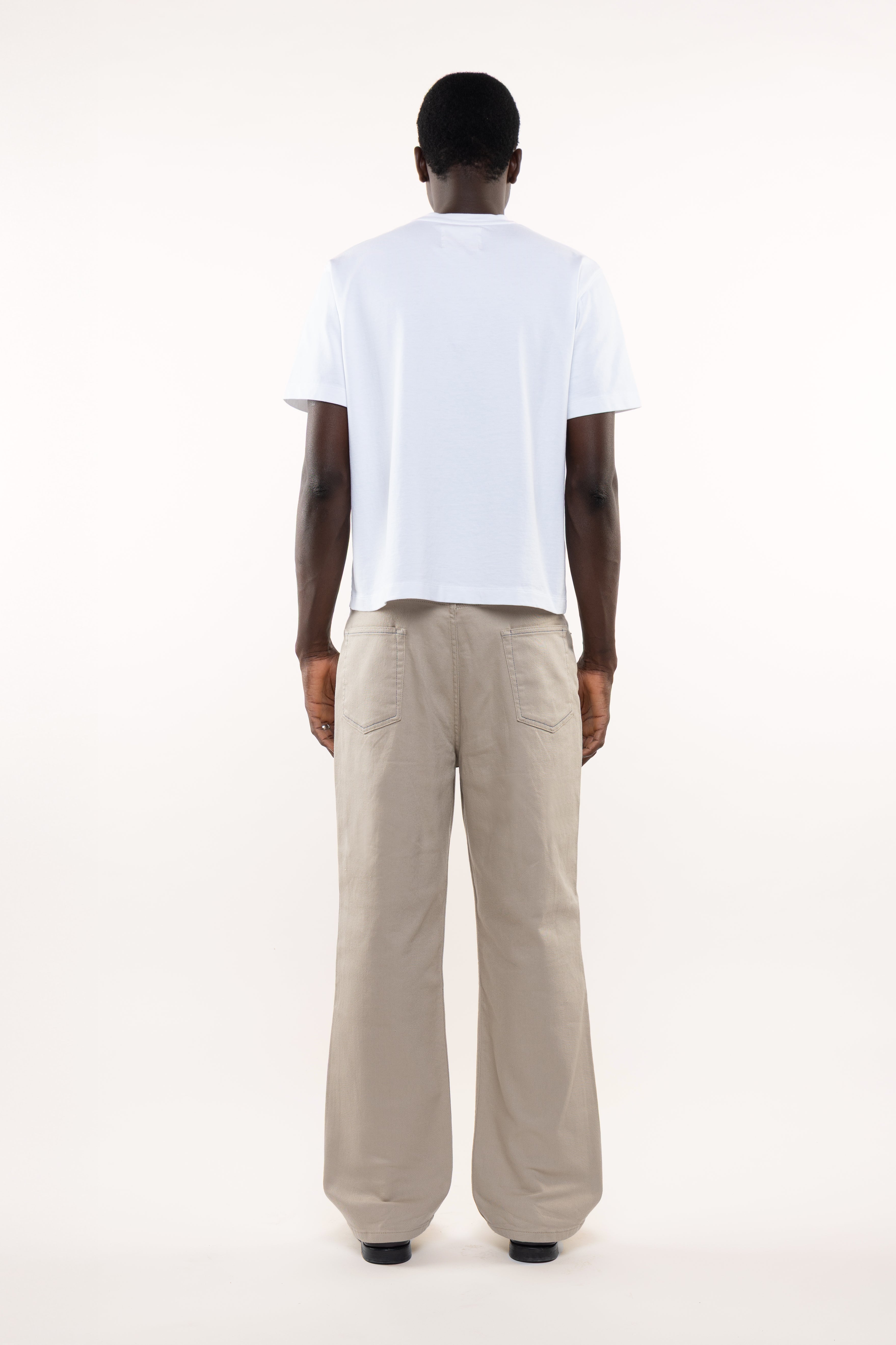 Back view of plain white T-shirt worn by male model