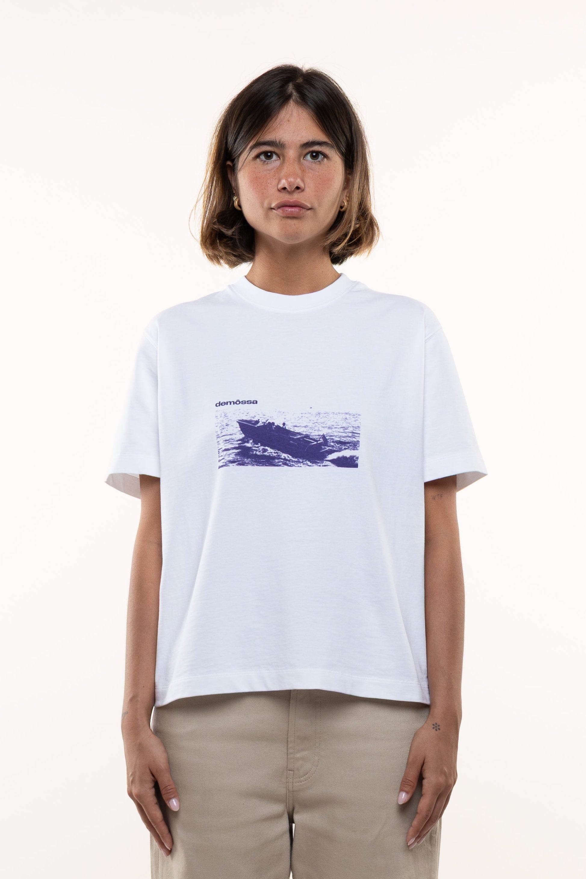 Front view of women’s white T-shirt with vintage boat graphic and small Demossa logo