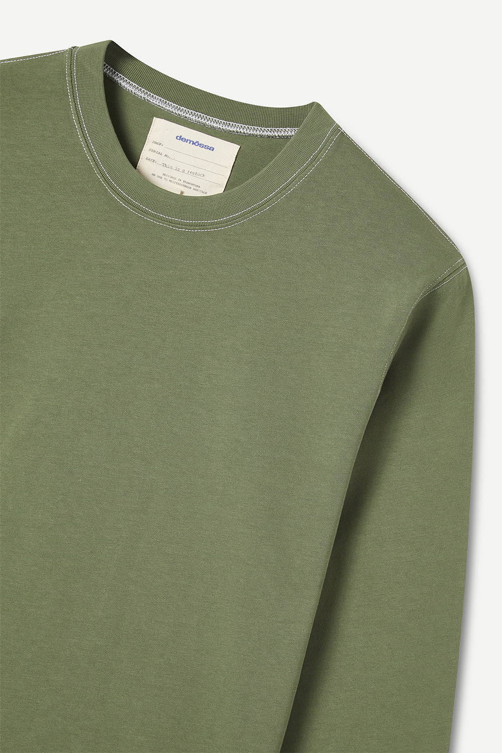 Green long-sleeve shirt with a brand label and contrast stiching on a white background