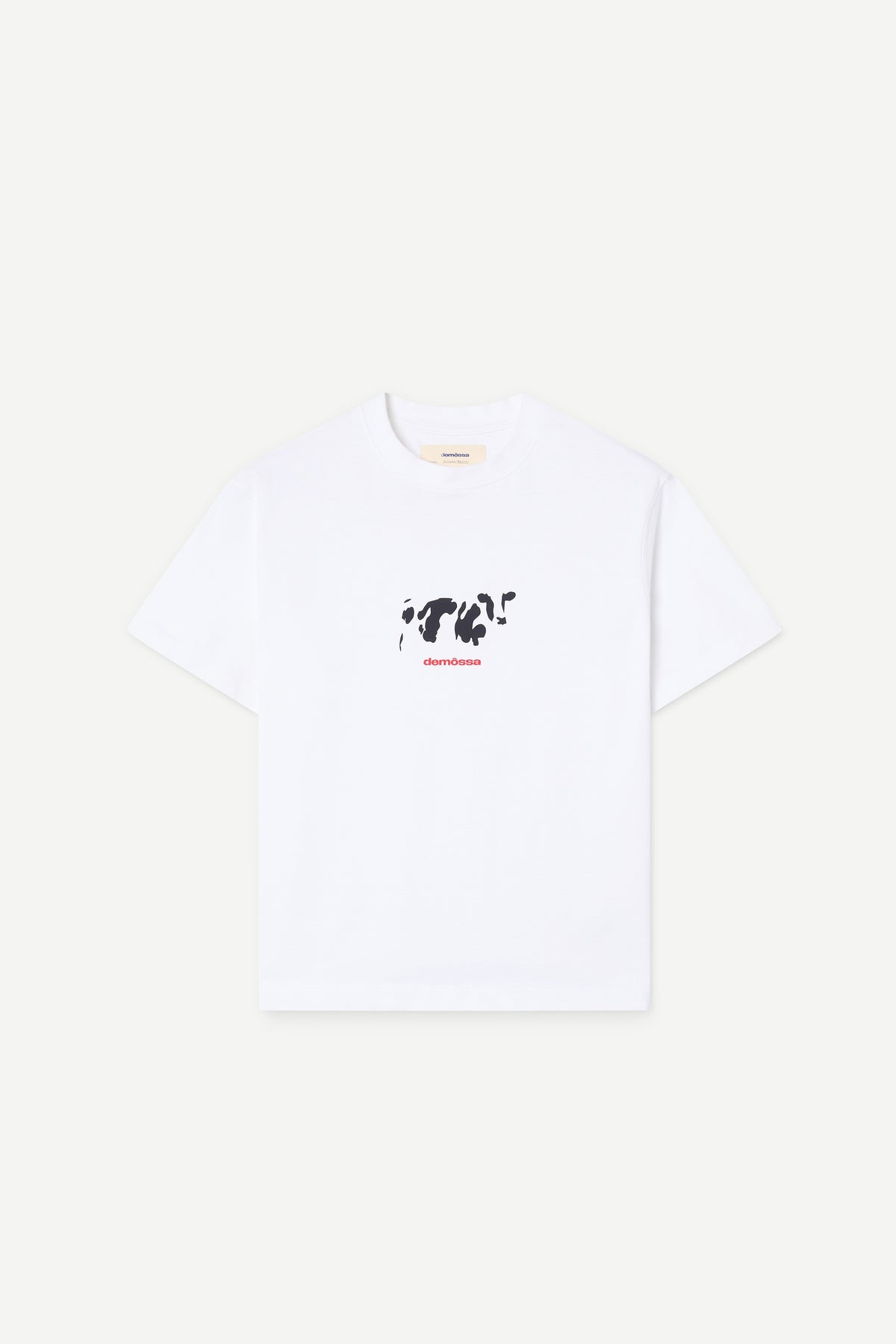 A white short-sleeve crewneck t-shirt with a black cow graphic and red text on the chest, displayed flat against a light off-white background.