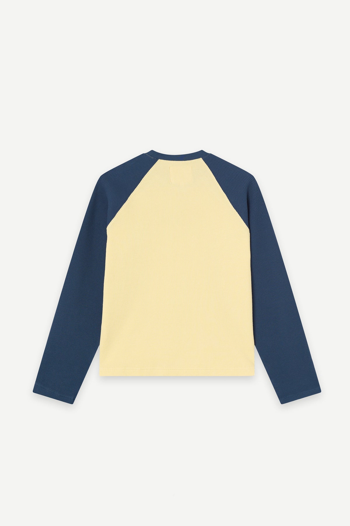 A long-sleeve raglan-style top shown from the back, featuring a pale yellow main body and dark navy sleeves, displayed on a clean light gray background.