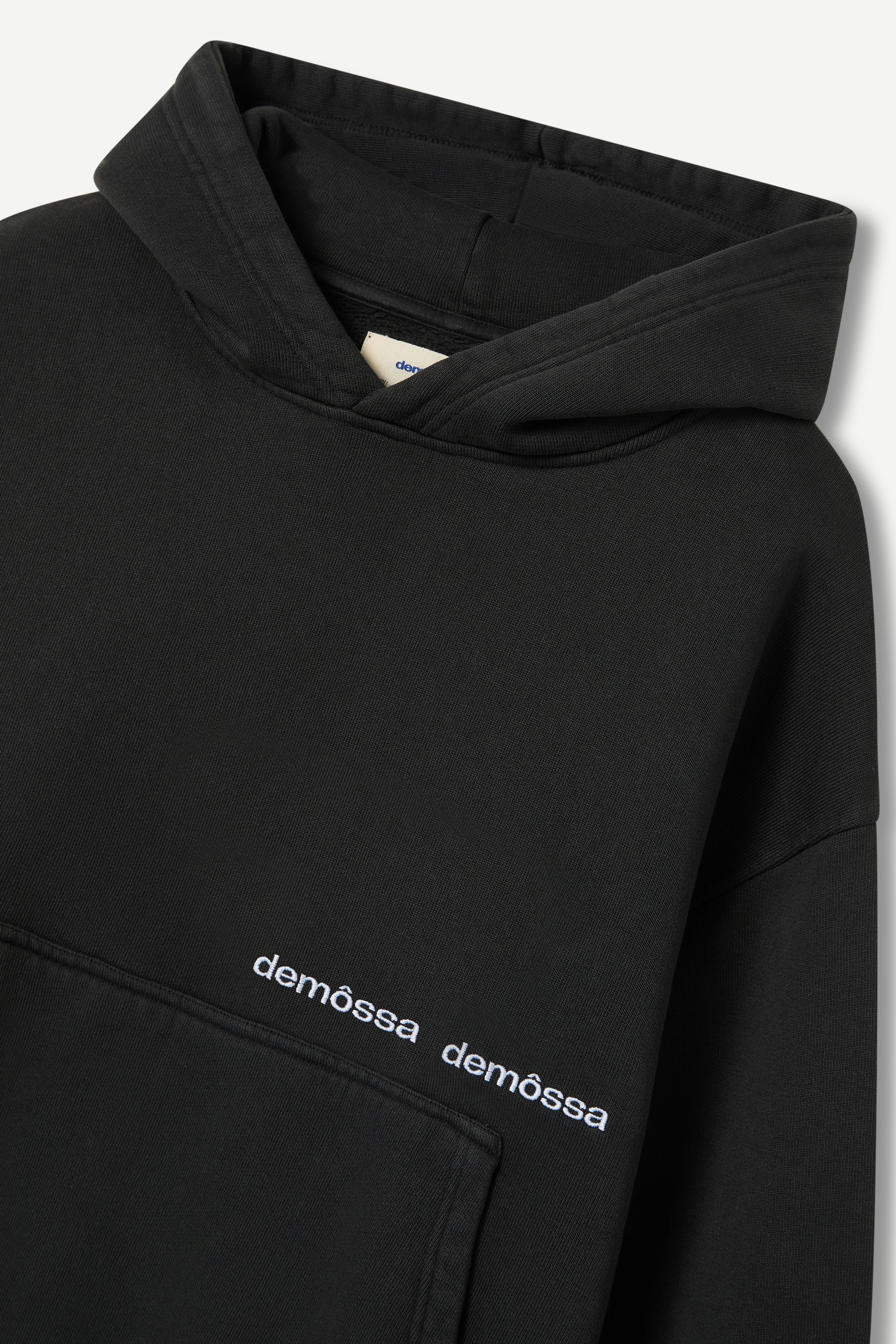 Black hoodie with 'demôssa' branding on a white background