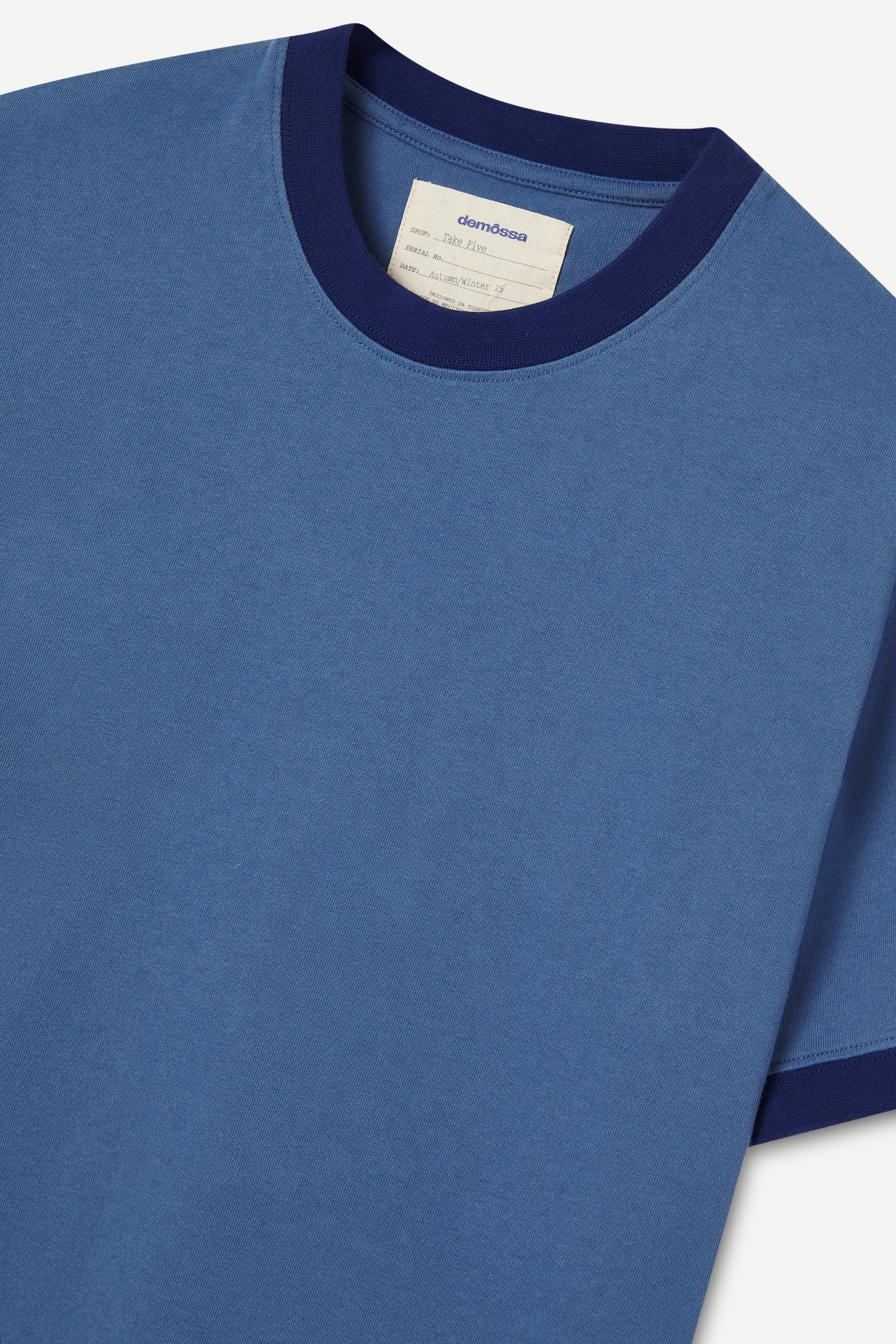 Blue t-shirt with navy trim on a white background