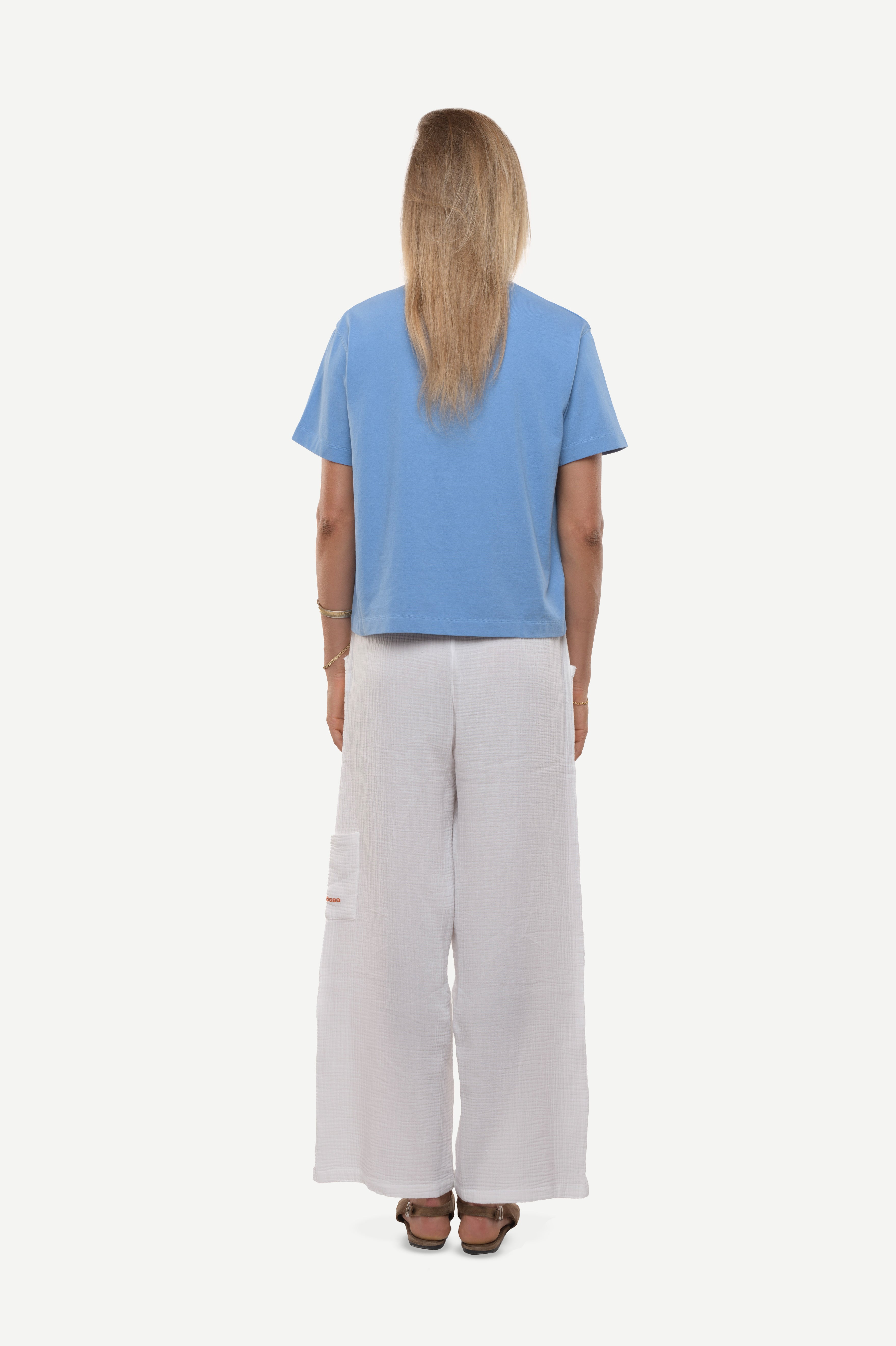 Back view of woman wearing a blue t-shirt on a white background