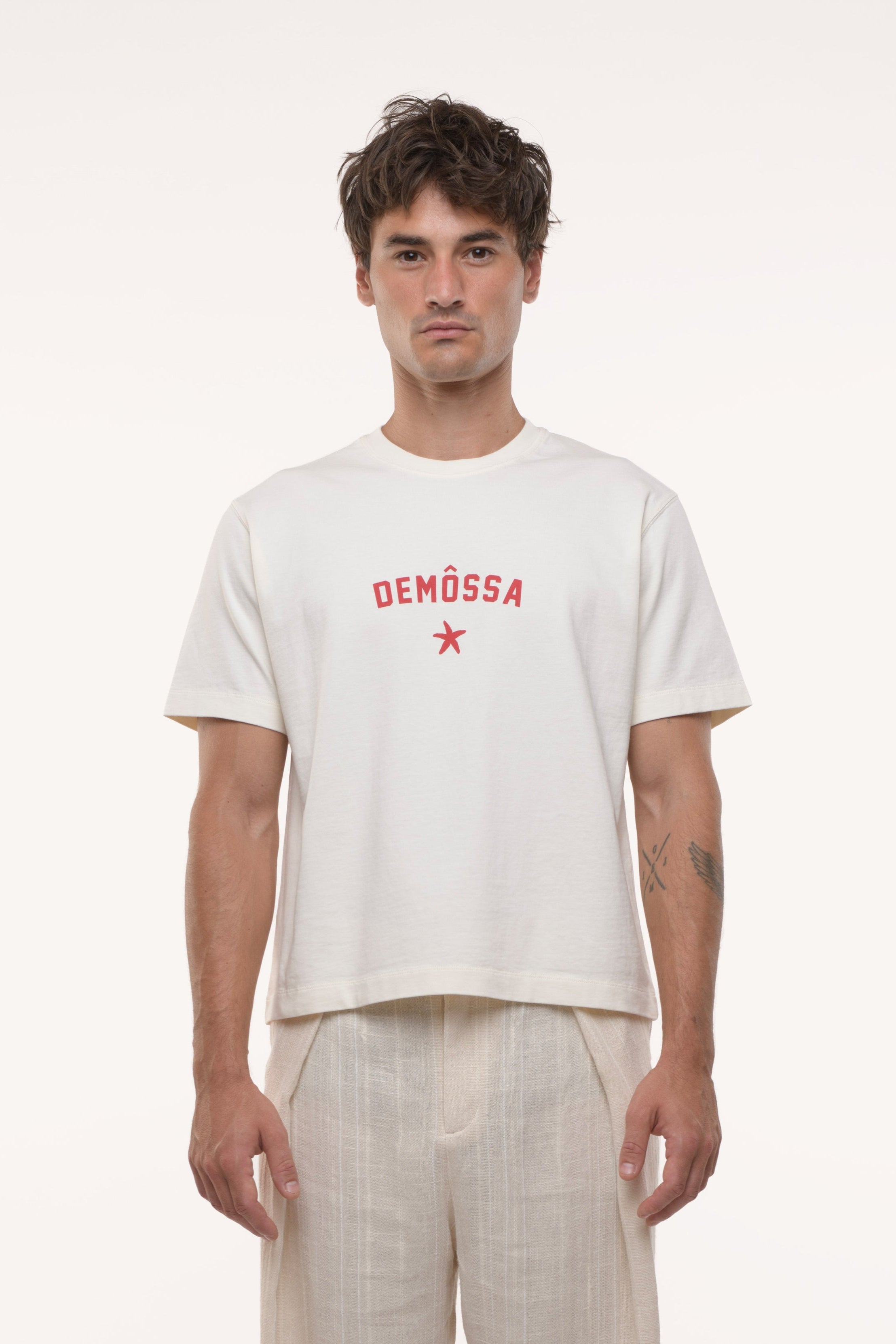 Man wearing a white t-shirt with red text and star design on a white background