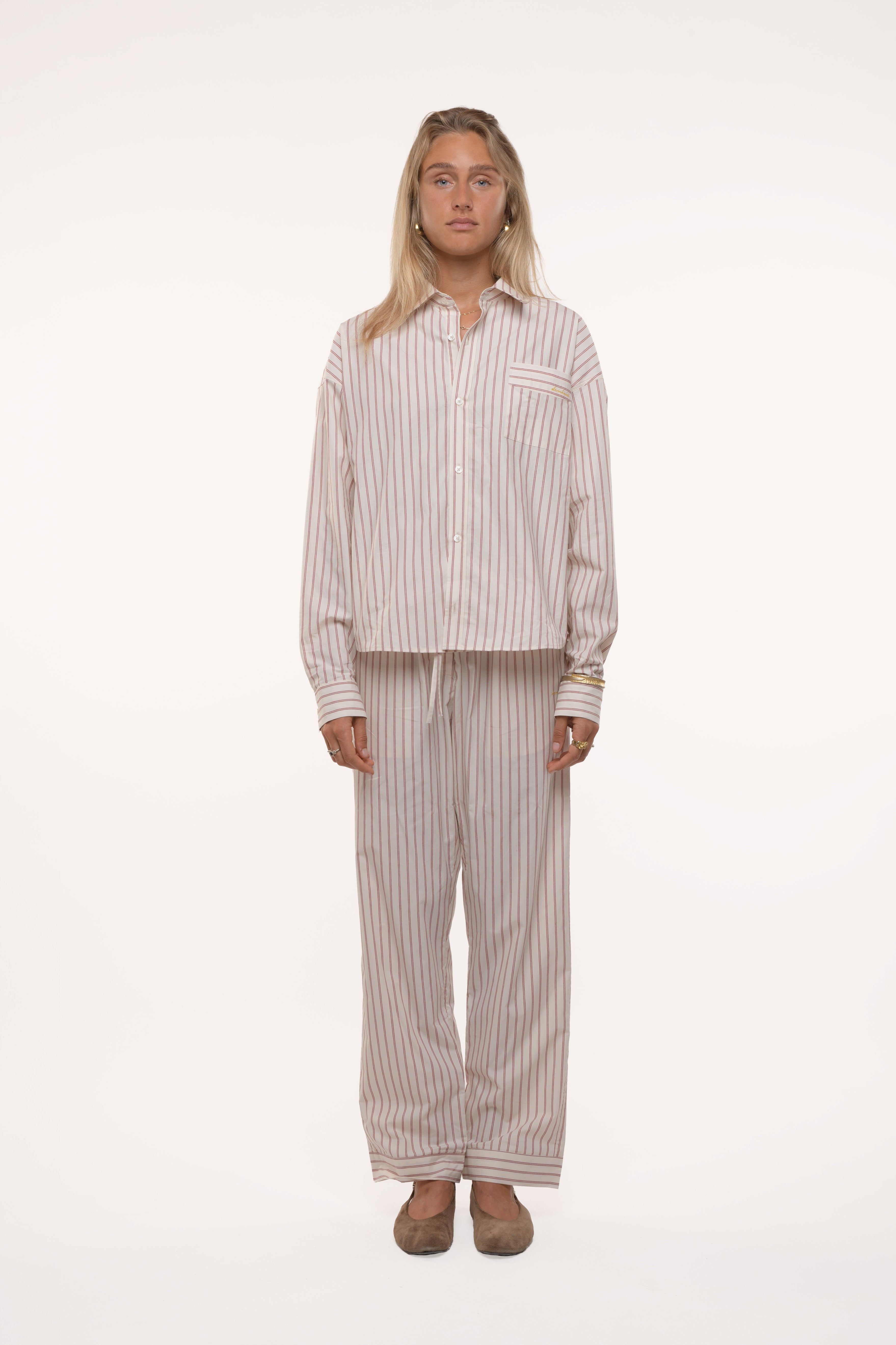 Woman wearing a striped pajama set on a white background